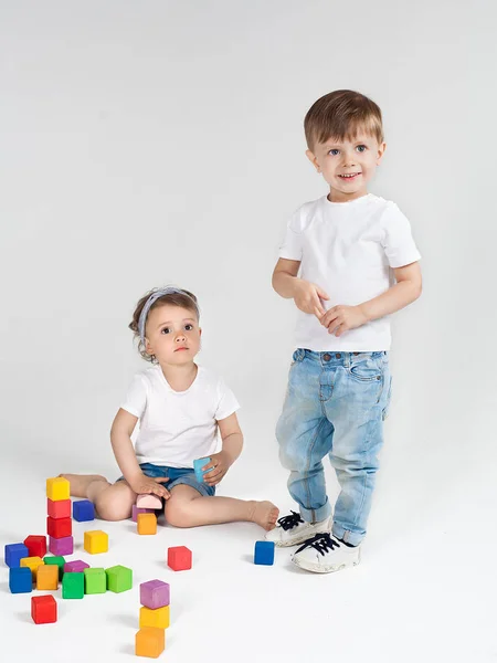 Boy and girl playing in colorful cubes — Stock Photo, Image