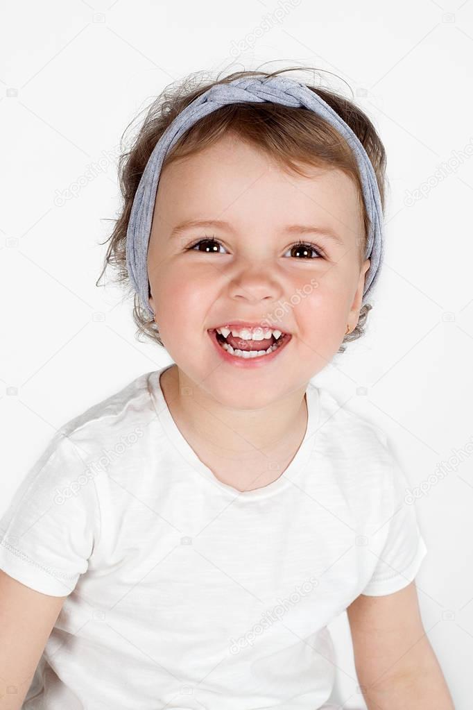 A beautiful funny little girl laughing on white background