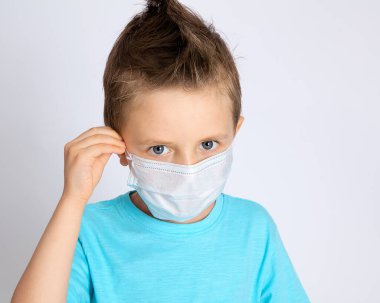 Sağlık maskeli bir çocuk arka planda bir virüse karşı