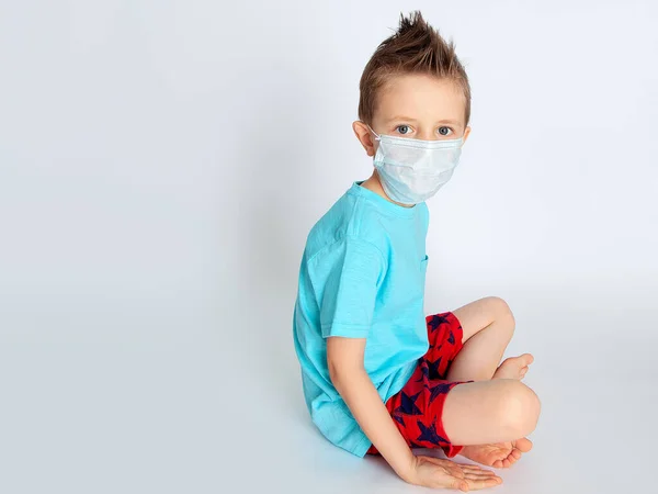 Tıbbi Maskeli Bir Çocuk Yerde Yarı Çıplak Bir Şekilde Oturuyor — Stok fotoğraf