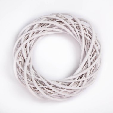 Beyaz arka planda örülmüş bir çelenk. Ürün el yapımı, dekoratif sanat. Dekorasyon ve tasarımda, çiçeklerde, tatillerde, düğün dekorlarında kullanılır..