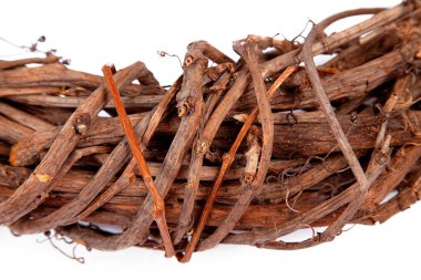 Örülmüş asma çelengi yakın plan. Beyaz arkaplandaki doku ve arkaplan resmi. Doğal malzemeden yapılmış..