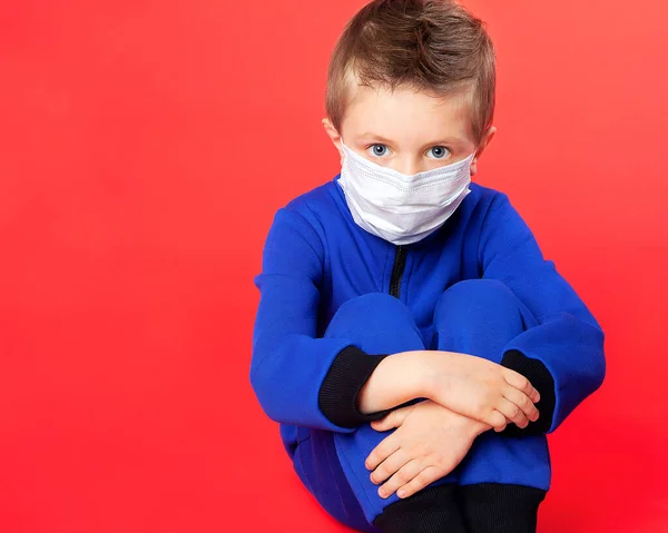 Tıbbi Maskeli Mavi Gözlü Bir Çocuk Kırmızı Arka Planda Endişeli — Stok fotoğraf