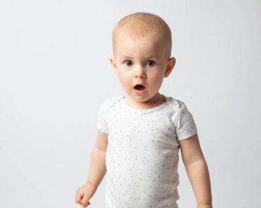 Avrupalı çocuk şaşırdı, ağzını açtı. Çocukların duyguları, doğallık. Yakın plan, beyaz arka planda bir çocuğun portresi..