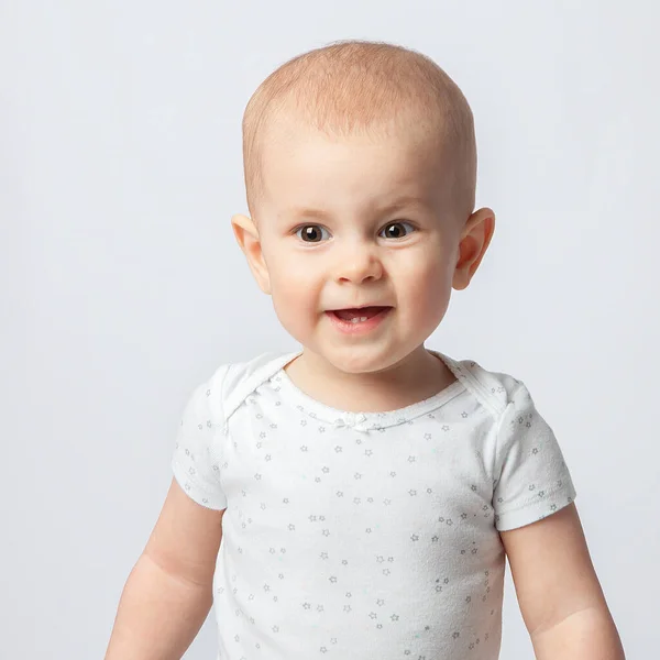 Bayi Perempuan Dengan Latar Belakang Putih Tersenyum Menyipitkan Mata Membuat — Stok Foto