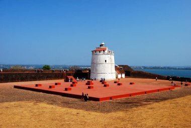 The lighthouse of the Aguada Fort in Candolim, Goa, India overlooking the Arabian Sea clipart