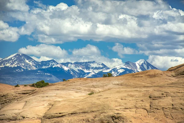 Montagne desertiche e montagne innevate a contrasto — Foto Stock