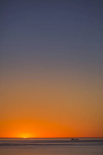 Minimalistisches Boot und Sonnenuntergang am unteren Rand des Rahmens — Stockfoto