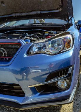 Başlık ile mavi bir araba gösterisinde motoru bileşeni attı
