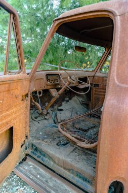 Orman kalıntı eski araba uzakta açık kapı ile ormanda paslanma