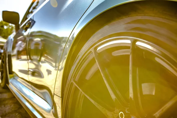 Car rim and side close up with a natural, in-camera lens flare