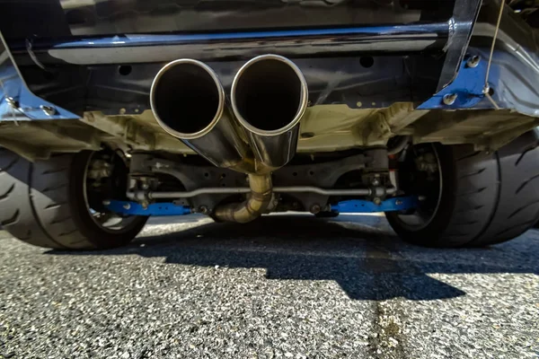 Chrome uitlaatpijp aan de onderkant van de auto met uitzicht op zeer ruime — Stockfoto