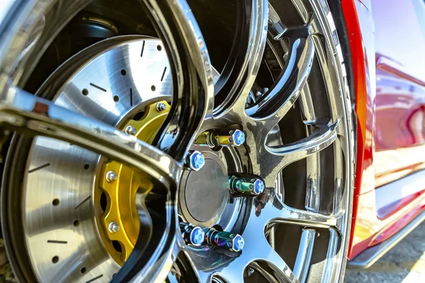 Bir araba kırmızı tarafının bir arka plan ile krom jantlar