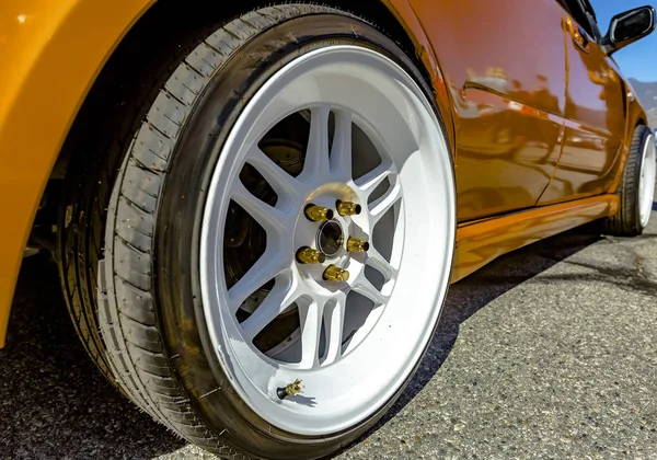 Llantas blancas planas en un coche naranja — Foto de Stock