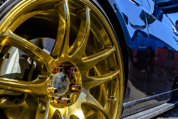 Golden rims on a black car looking very reflective — Stock Photo, Image
