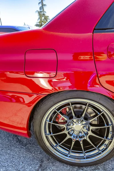 Red car with chrome spokes and red break pads showing between th — Stock Photo, Image