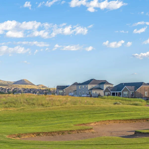 Square Golf pálya és házak távoli hegy és kék ég kilátás egy napsütéses napon — Stock Fotó
