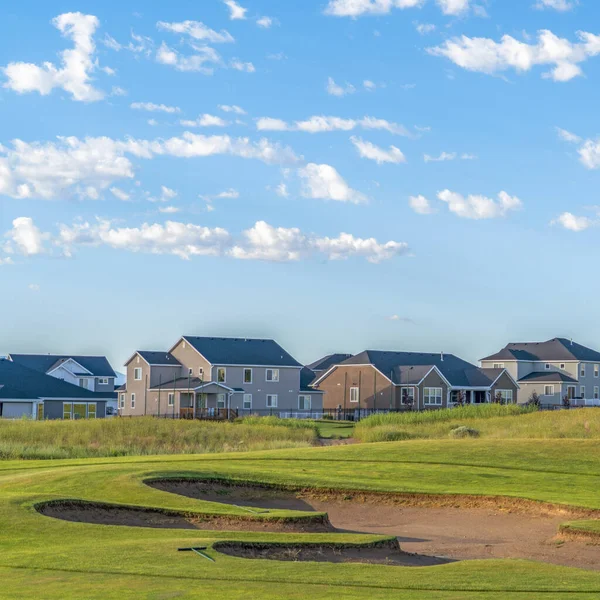 Quadratischer Rahmen Golfplatz und Häuser mit Fernsicht auf die Berge und blauen Himmel an einem sonnigen Tag — Stockfoto