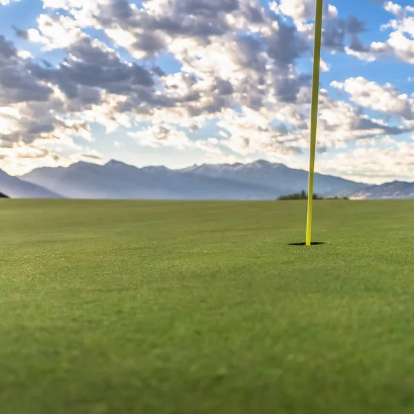 Čtvercový rámeček Flagstick nebo pin a díra nebo pohár uprostřed uvedení zelené na golfovém hřišti — Stock fotografie