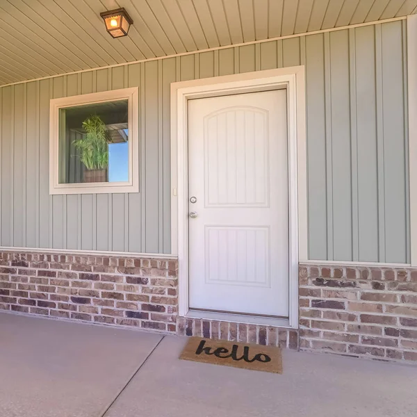 Square frame Front door and porch of home with welcome mat