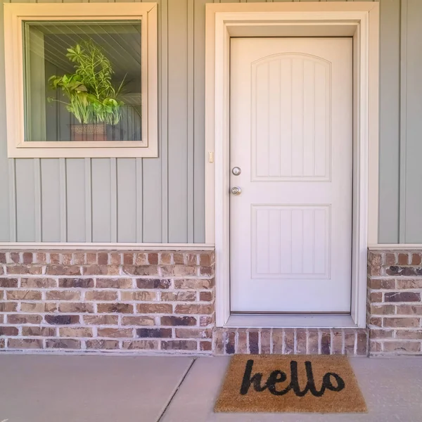 Square Front door and porch of home with hello mat