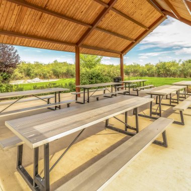 Çatı altında masaları ve koltukları olan bir parkın köşesindeki kare görüntüyü kapat.