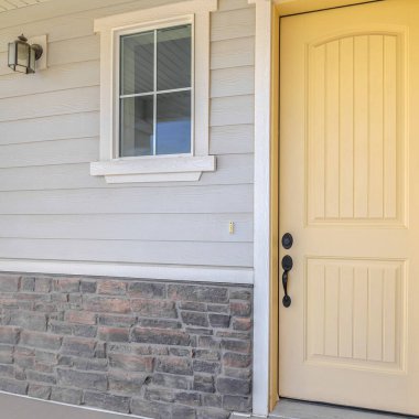 Banliyö evinin ön verandasında sarı kapılı kare çerçeve.