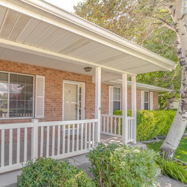 Square Front porch and garden of traditional brick home