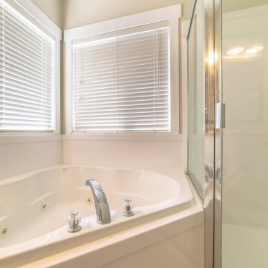 Küvete bitişik duş kabini olan temiz bir evin içi.