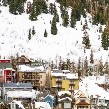 Kışın Utah Park City 'de karla kaplı bir dağdaki evler ve kulübeler.