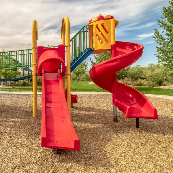 Square Focus on empty childrens playground at a park with red slides and climbing bars — ストック写真