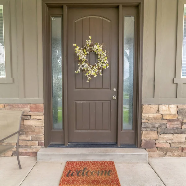 Square Flower wreath on a brown front door with sidelights and windows on both sides