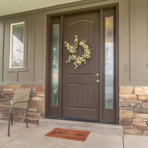 Square frame Porch and front door of a home with wood and stone brick wall sections