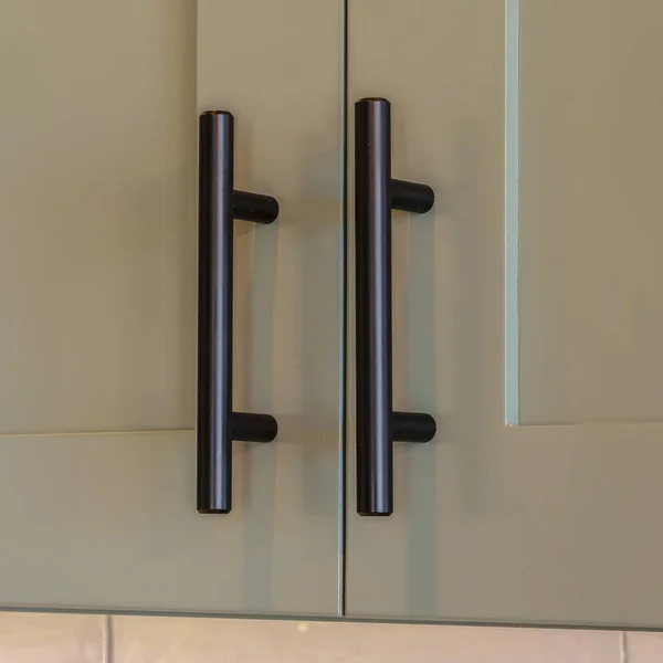 Square frame Close up of overhead kitchen cupboard handles
