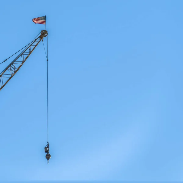 Vierkant Close-up van een kraan op een bouwplaats met helderblauwe lucht achtergrond — Stockfoto