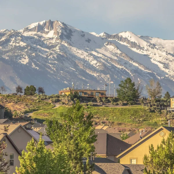 Square Family homes at a neighborhood with view of a snow covered mountain against sky