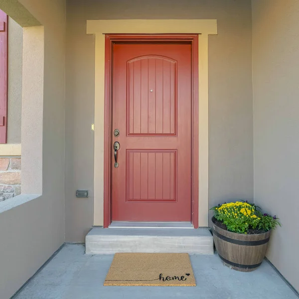 Square frame The red front door of a house with concrete exterior wall and shutters on window — ストック写真