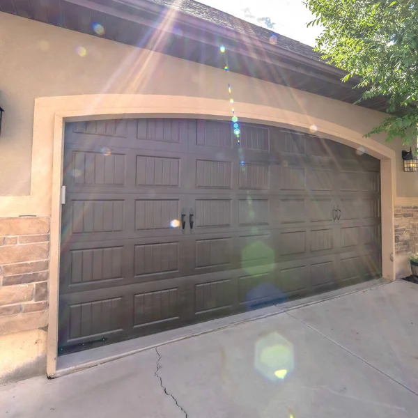 Cornice quadrata Esterno di una casa con ampia porta del garage ad arco contro la luce solare e il cielo — Foto Stock