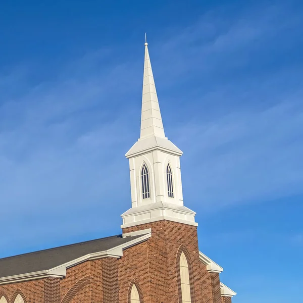 Quadratische Außenfassade einer Kirche mit roten Ziegelwänden und Bogenfenstern und weißem Kirchturm — Stockfoto