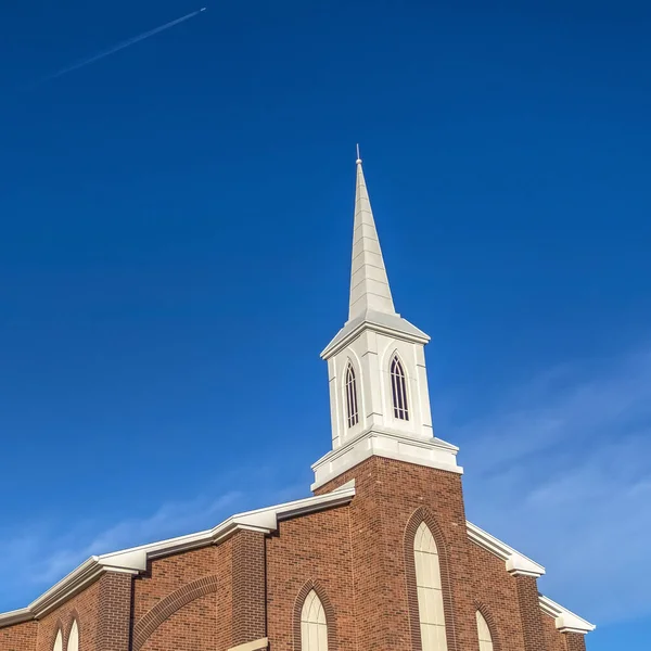 Kare çerçeve, beyaz çan kulesi ve parlak mavi arkaplanı olan bir kilisenin güneşli gündüz manzarası. — Stok fotoğraf
