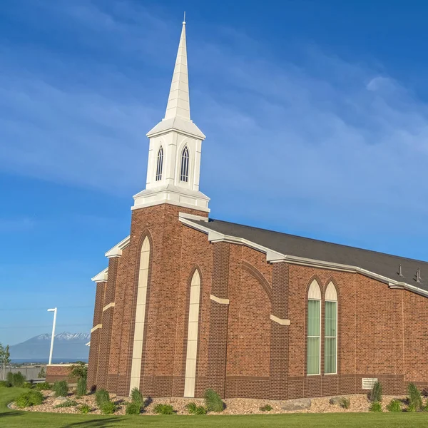 Marco cuadrado Exterior de una iglesia con paredes de ladrillo rojo ventanas arqueadas y campanario blanco — Foto de Stock