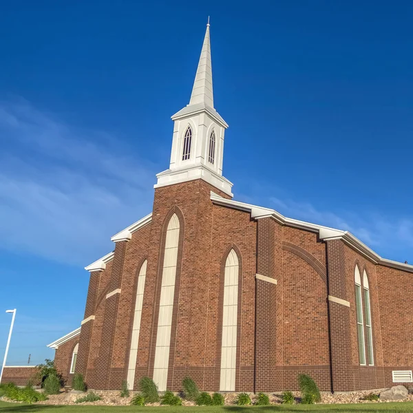 Квадратный вид на солнечный день церкви с белой крутизной и ярким голубым фоном неба — стоковое фото