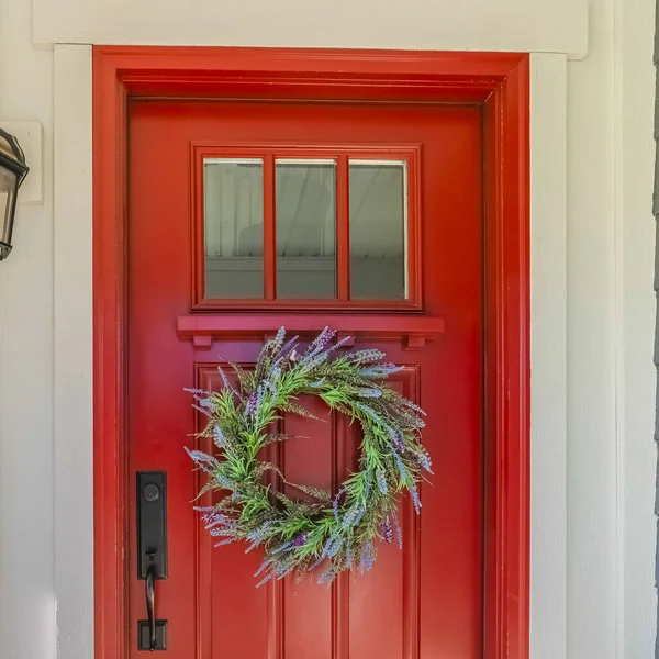 Square Red front door of modern home with green wreath