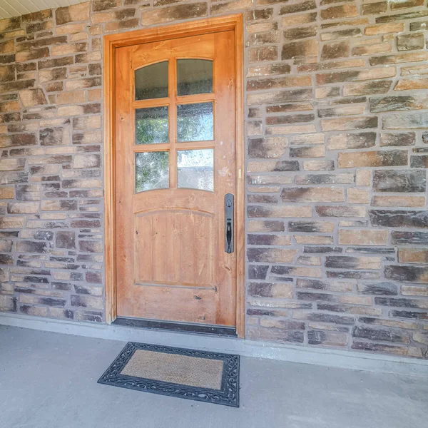Деревянная передняя дверь современного дома с каменными стенами — стоковое фото