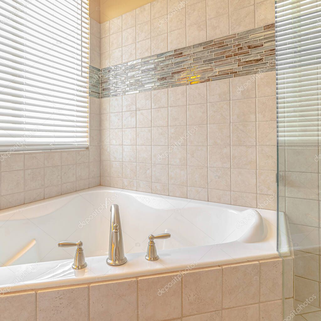 Square Tiled bathroom and spa with bright window lighting