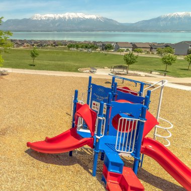 Dağa bakan renkli oyun parkı ve mavi gökyüzüne bakan gölü olan Square Park