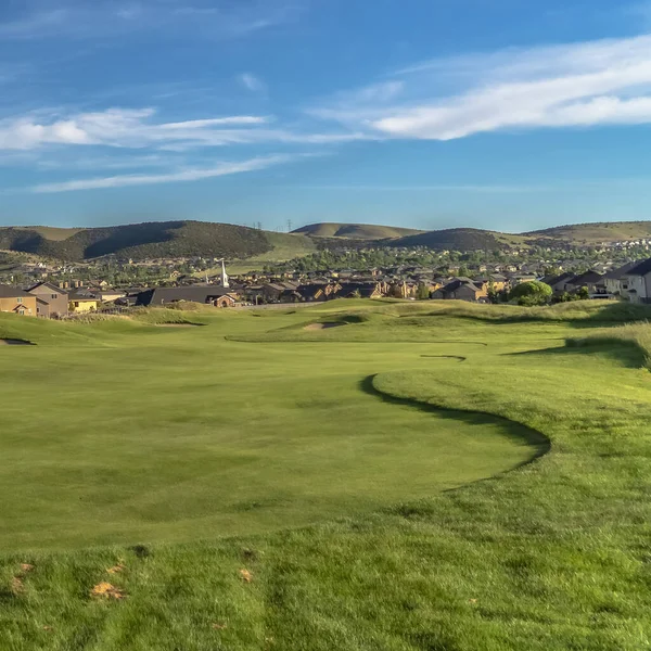 Pole golfowe i domy z widokiem na góry w oddali — Zdjęcie stockowe