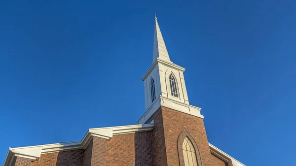 Panorama Iglesia con clásica pared exterior de ladrillo rojo y campanario blanco contra el cielo azul — Foto de Stock