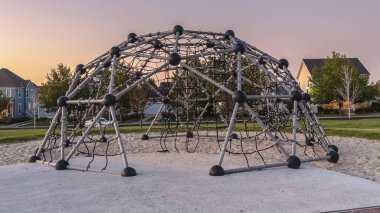 Panorama Metali gün batımında bir oyun parkında tırmanma çerçevesi