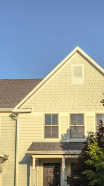 Akşam ışığında büyük sarı bir evin dikey cephesi